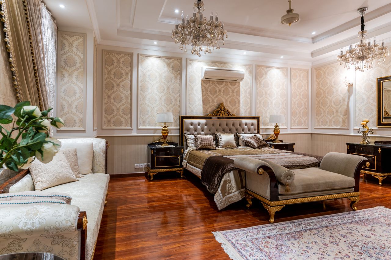 services-01 Opulent bedroom featuring a grand bed, chandeliers, and rich decor elements.