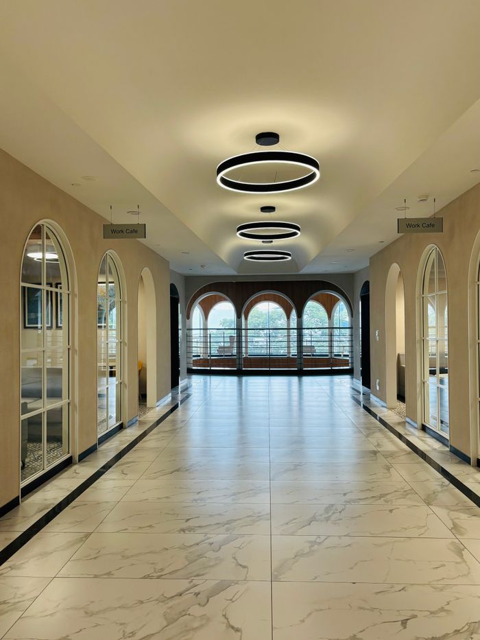 Spacious corridor with elegant lighting and arched windows, ideal for business settings.