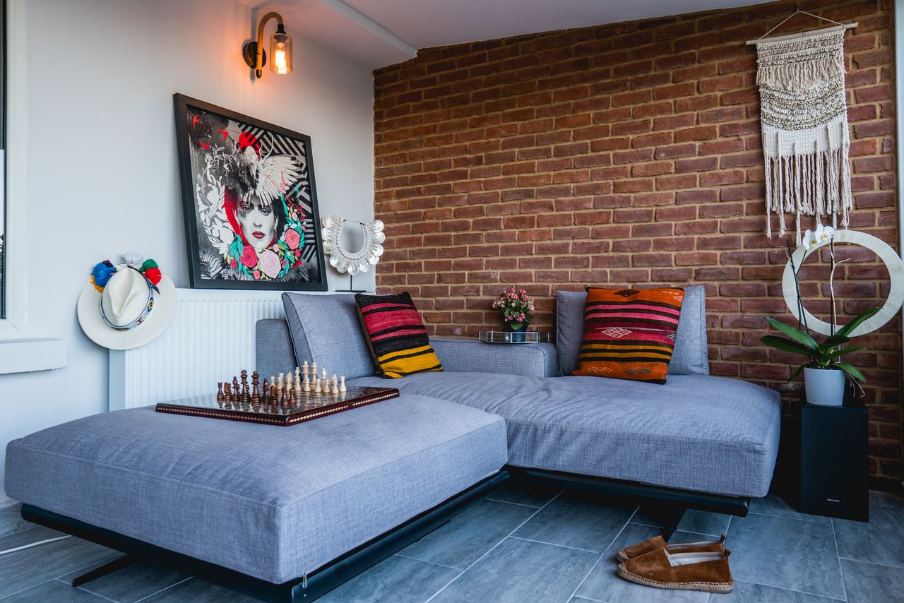 gallery-6 Stylish living room featuring a modern couch, vibrant artwork, and chessboard for a relaxed ambiance.